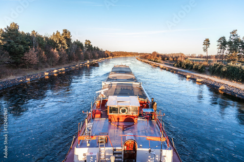 inland vessel drives a canal river along photo