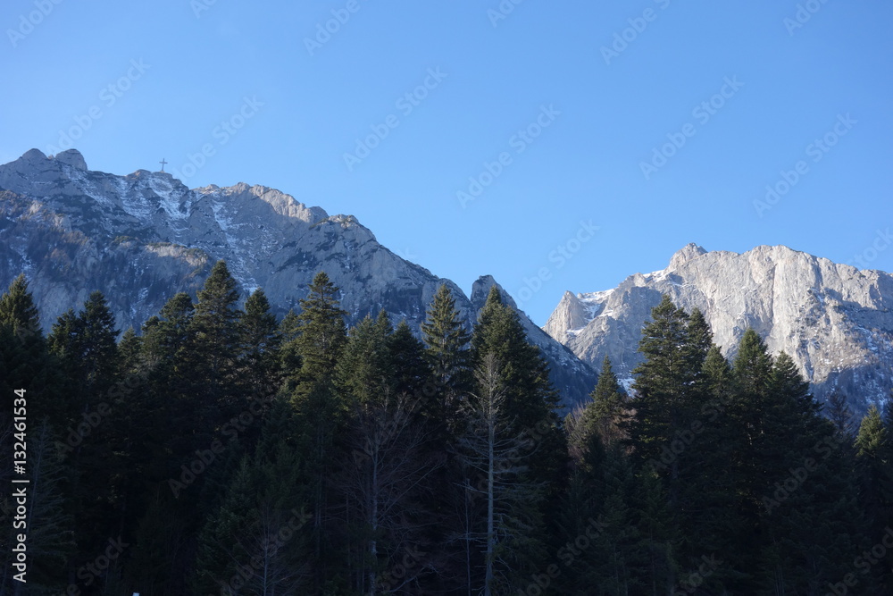 Rocky crests in Bucegi mountains in Romania with heroes cross on Caraiman peak