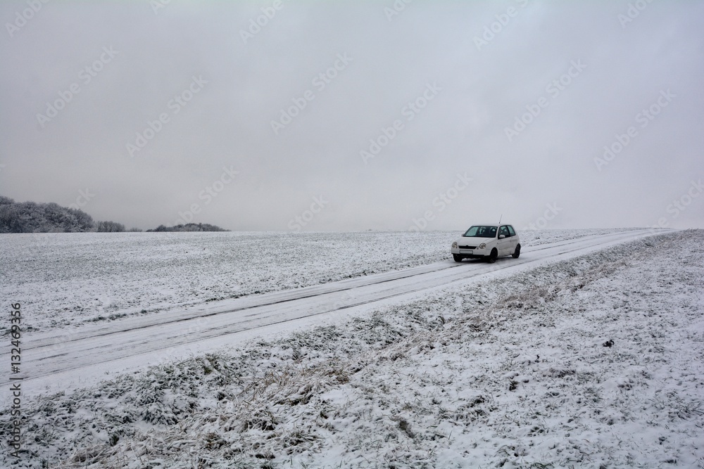 Weißes Auto auf schneebedeckten Feldweg
