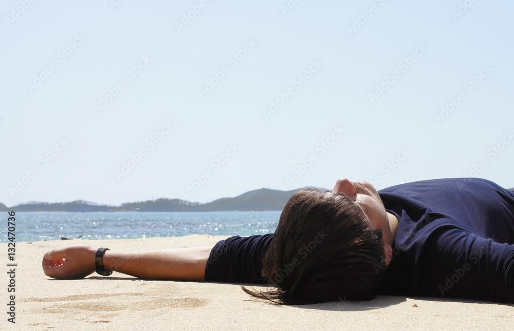 a man is lying on the beach