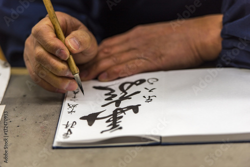 Japanese man writing the name and wishes to a tourist in Japan