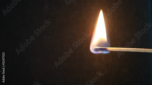 Burning matchstick on black background photo