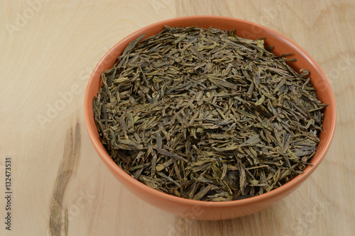 Bowl of dry loose lung ching Chinese green tea leaves  photo