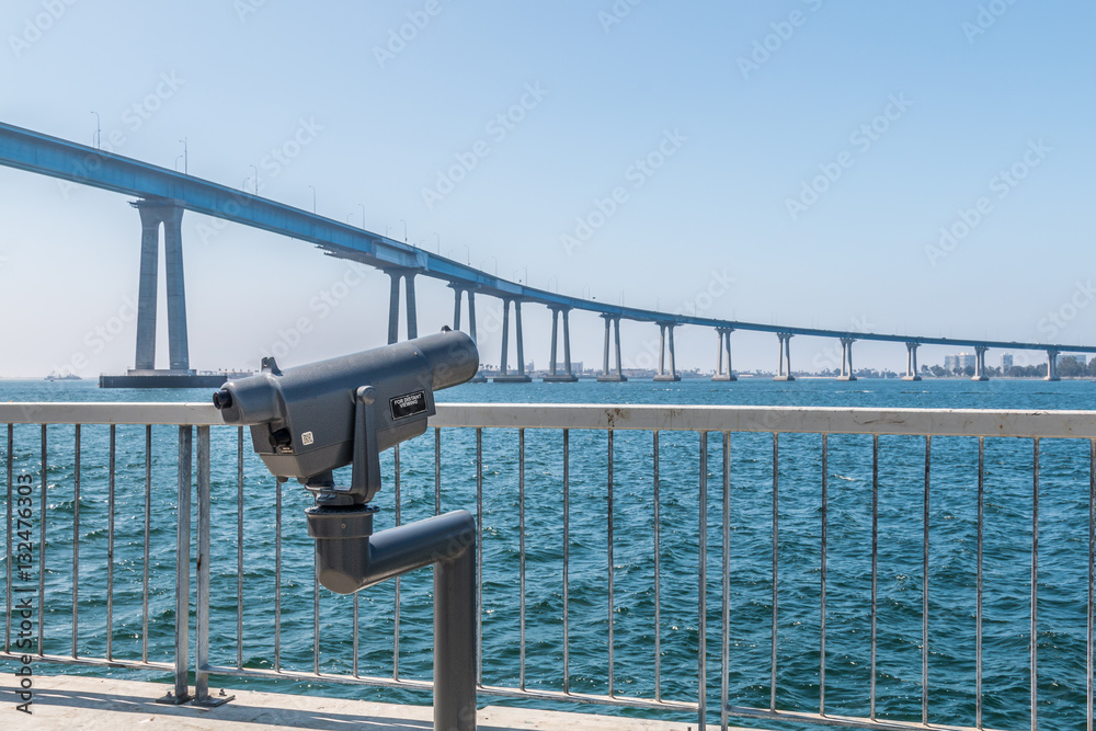 Sightseeing binoculars on the Cesar Chavez Park viewing pier, overlooking the San Diego bay and the Coronado bridge. Sightseeing binoculars on the Cesar Chavez Park viewing pier, overlooking the San Diego bay and the Coronado bridge.
