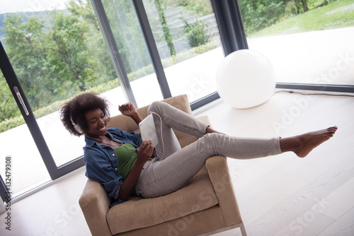 Wallpaper Mural African american woman at home in chair with tablet and head pho Torontodigital.ca