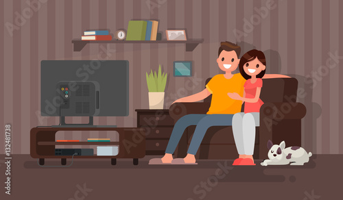 Young couple watching a movie. Man and woman sit on against the