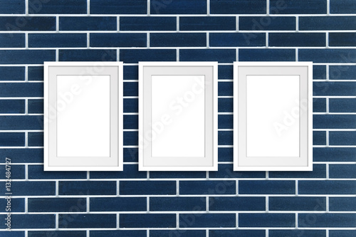Three white frames on navy blue decorative bricks wall  Exhibition style mock up