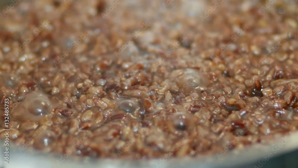 Red rice is boiling in a pot of water. Red rice is boiling in a pot of water.