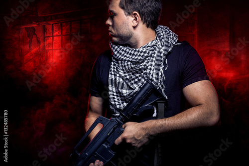Bilde på lerret Soldier with a gun surviving in the smoky ruins of an urban warzone on fire
