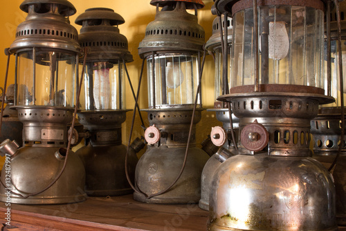 Group of old vintage storm lanterns, hurricane lamp put on vintage cabinet wood. Vintage lamp concept.