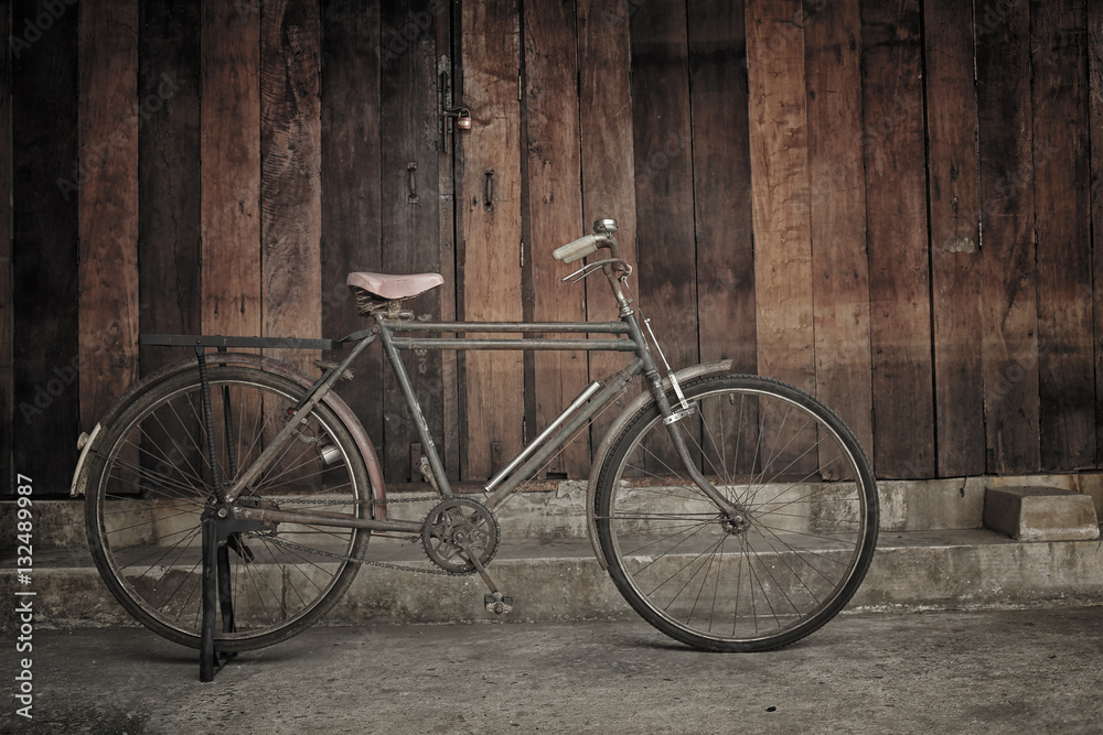vintage bicycle leaning against wooden wall
