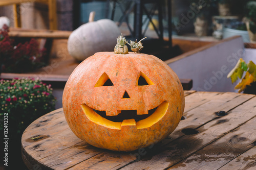 The smiling Halloween pumpkin is on a wooden surface