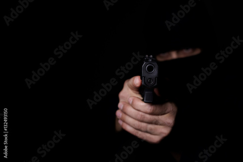 Man's hands aiming with gun.