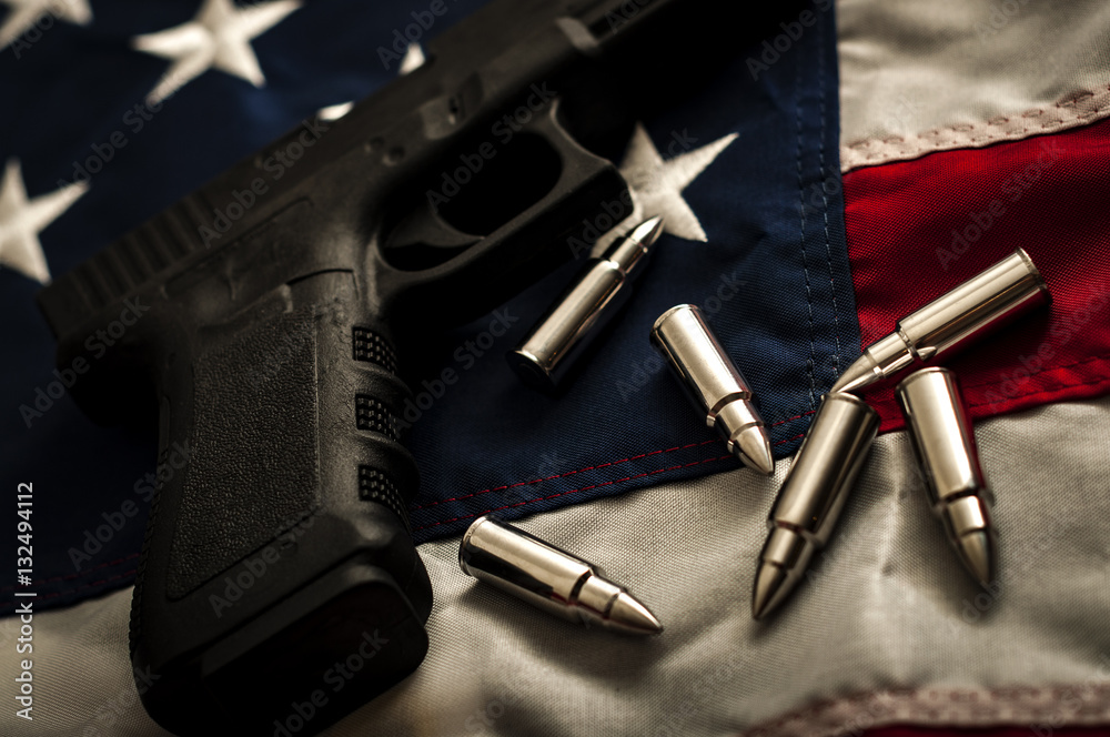 The second amendment and the right to bare arms concept with a grungy image of a gun and bullets on american flag. In the United States of America the 2nd amendment protects people's right to own guns