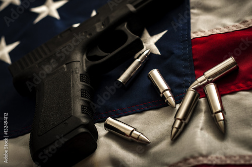 Obraz na płótnie The second amendment and the right to bare arms concept with a grungy image of a gun and bullets on american flag. In the United States of America the 2nd amendment protects people's right to own guns w salonie