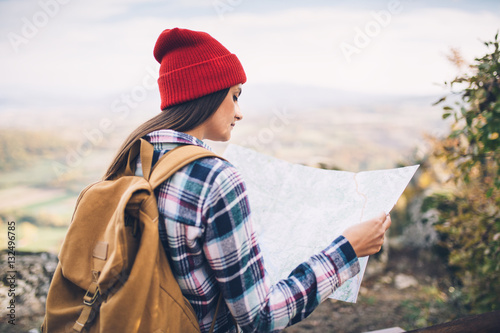 Hipster girl with red wool cap checking map © yossarian6