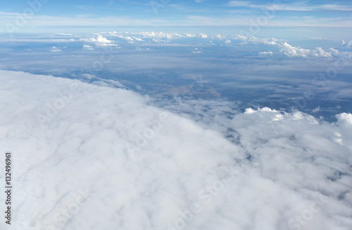 Aerial view on clouds and blue sky from airplane window