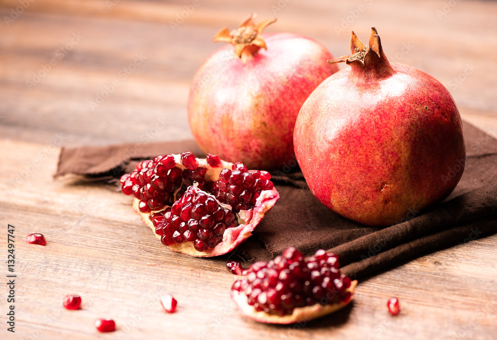 Pomegranate fruits with grains on wooden table. Pomegranate fruits with grains on wooden table.
