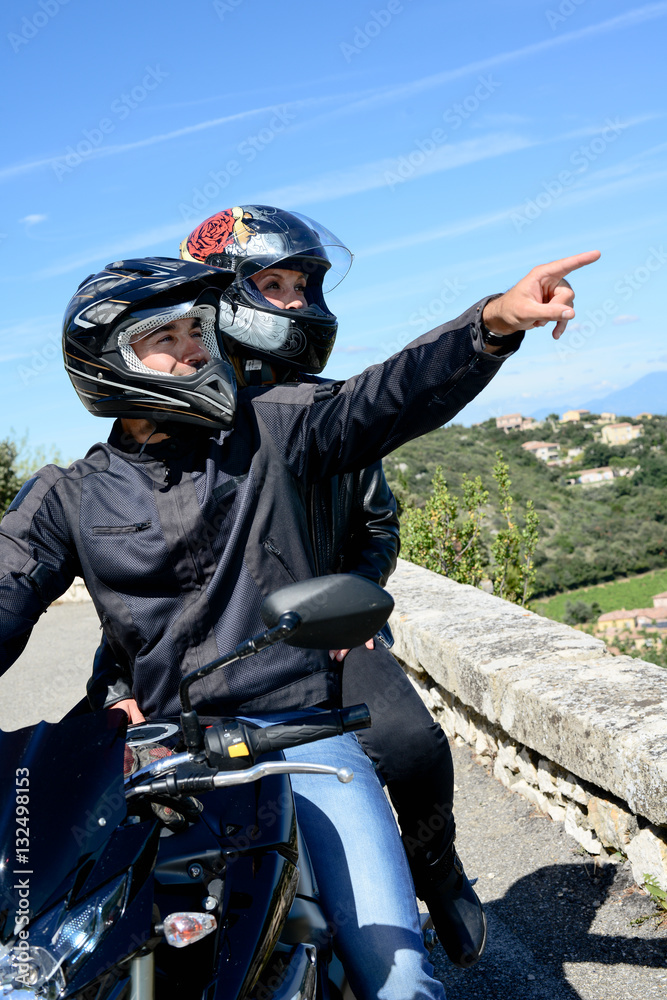 Obraz premium happy young biker couple riding their motorbike in summer