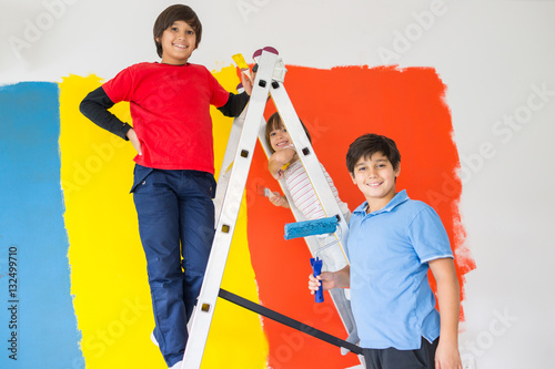 Children helping painting wall at home