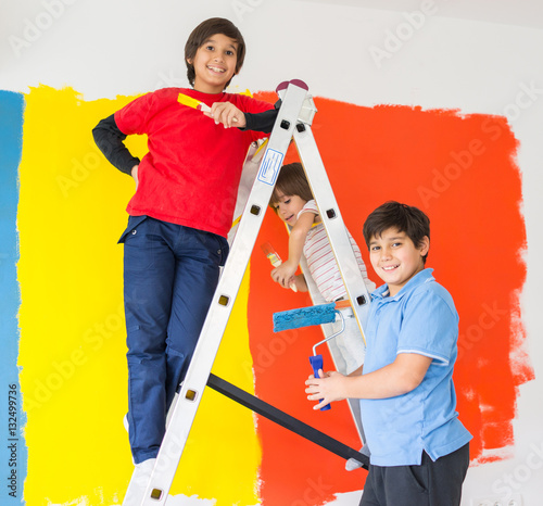 Children helping painting wall at home