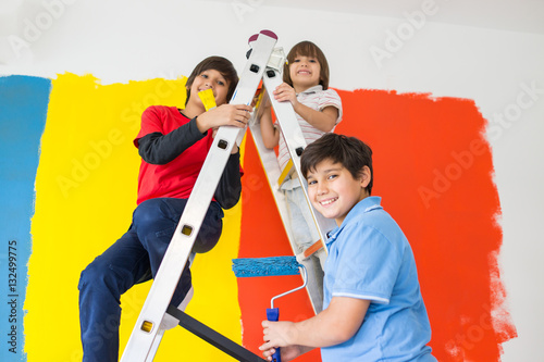 Children helping painting wall at home