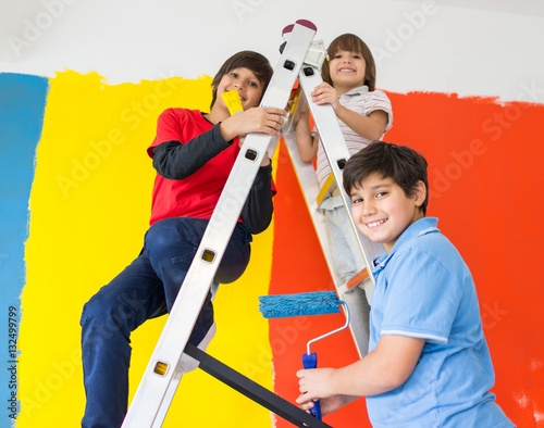 Children helping painting wall at home