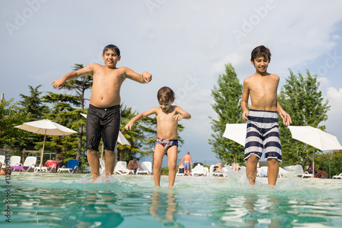 Happy time for kids of fun and enjoyment on summer swimming pool