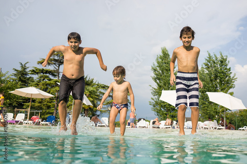 Happy time for kids of fun and enjoyment on summer swimming pool