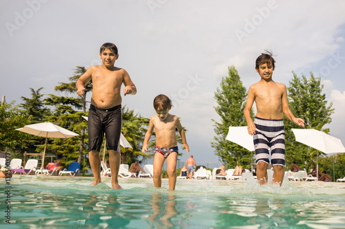 Happy time for kids of fun and enjoyment on summer swimming pool