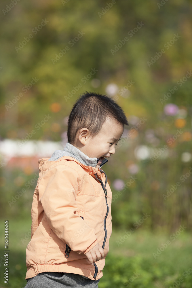 Happy baby boy playing a ball in a park Happy baby boy playing a ball in a park