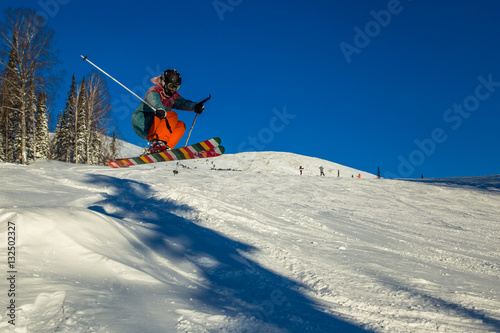 Skier on off-piste slope in forest riding very fast. Ski backcountry resort Sheregesh.