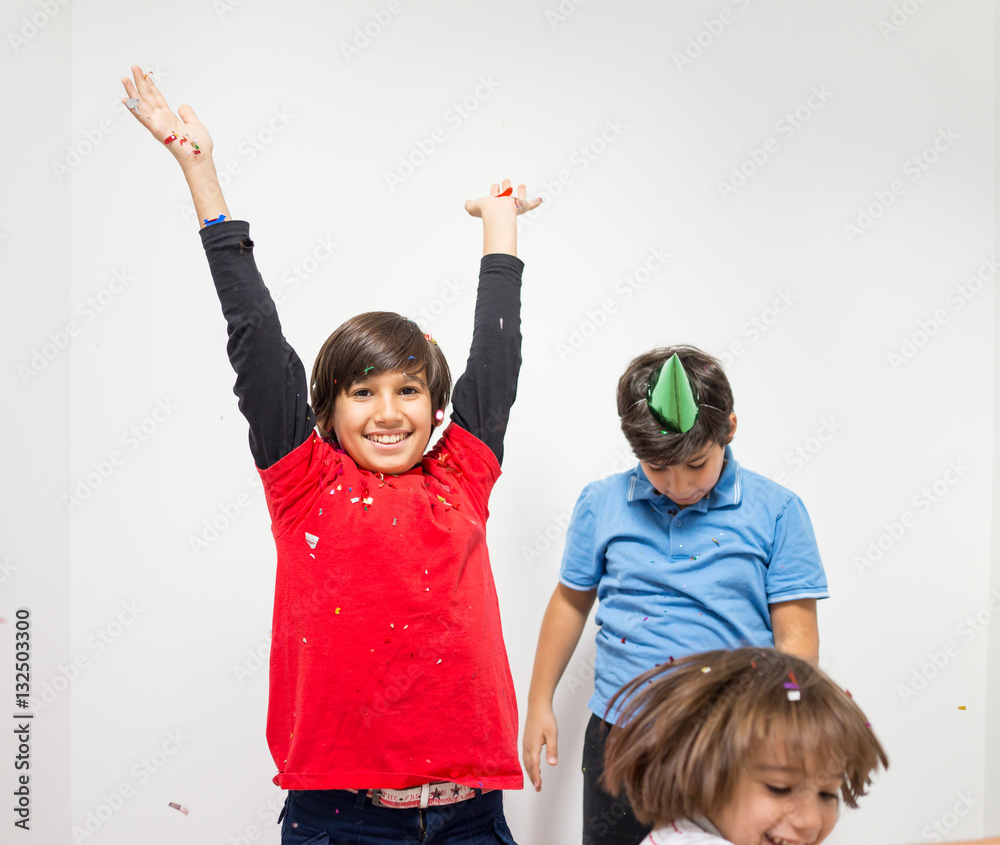 Happy kids celebrating party with blowing confetti Happy kids celebrating party with blowing confetti