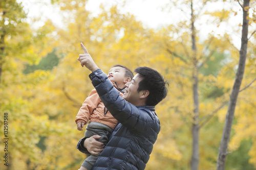 Happy real father and son pointing afar