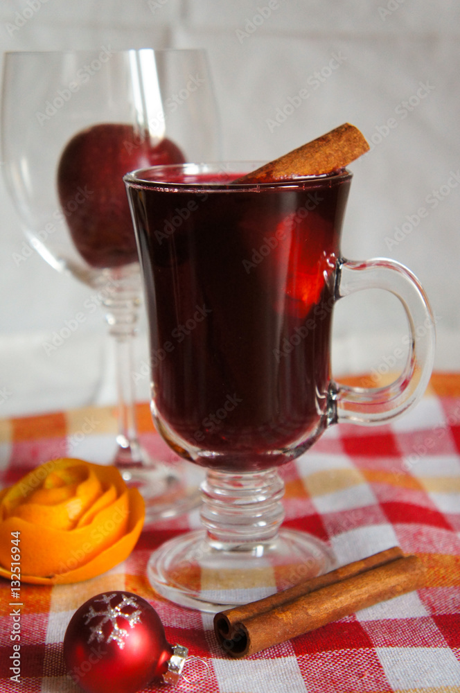 Mulled wine red with cinnamon on table with cloth in plaid Mulled wine red with cinnamon on table with cloth in plaid