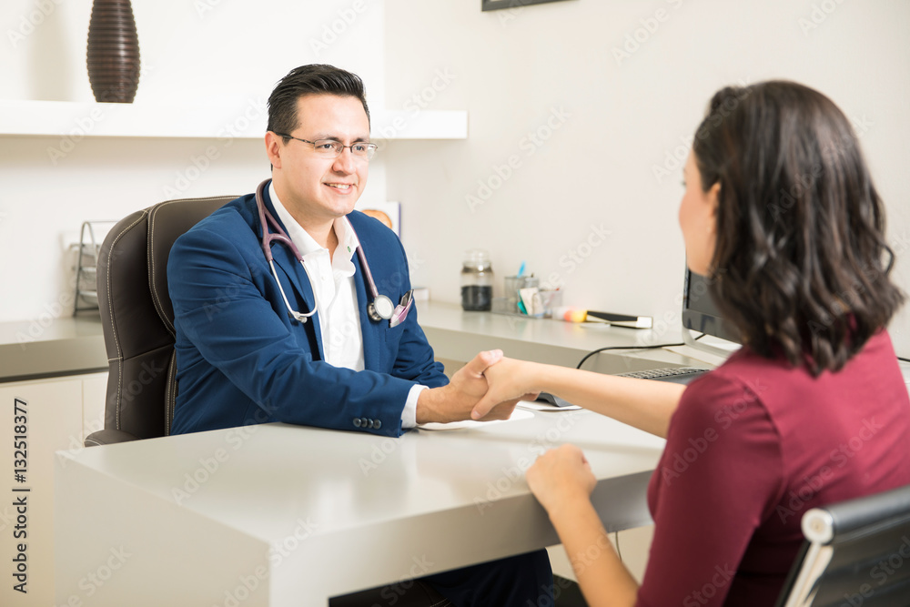 Handsome doctor greeting a patient