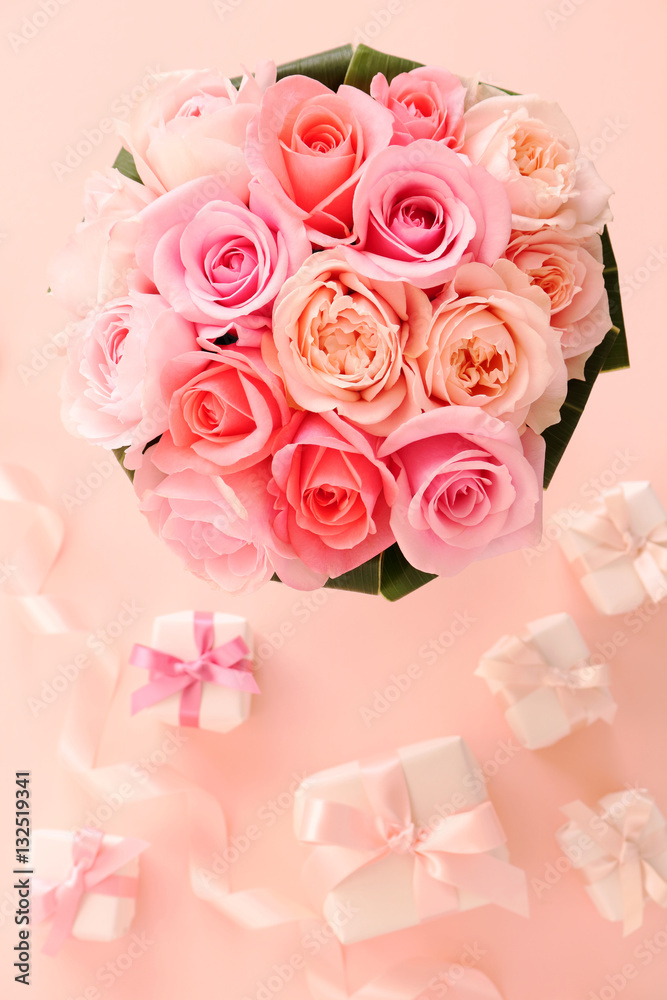  Bouquet of beautiful pink roses with gifts on pastel  pink background
