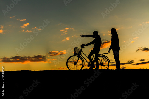 Silhouette of sweet couple in love happy time and bicycle in bea © Naypong Studio