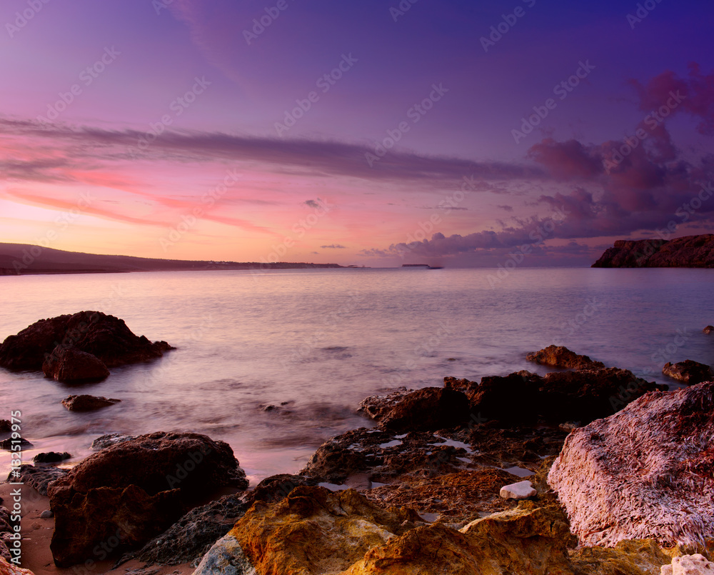 Beautiful colorful sunrise at the sea with dramatic clouds and boulders. Beauty world natural outdoors travel background
