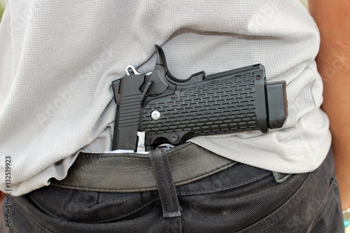 gangster concealing his gun behind his back