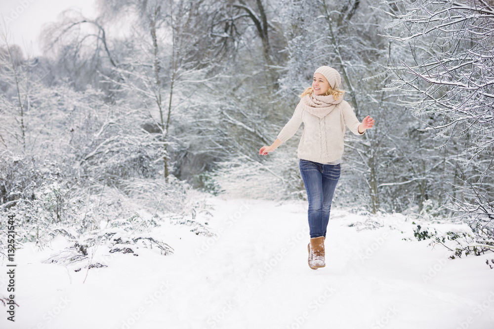 Happy young woman running and having fun in a winter park. Holidays and Christmas  concept. Girl outdoors.