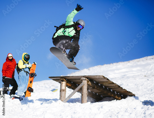 Jumping snowboarder on blue sky background