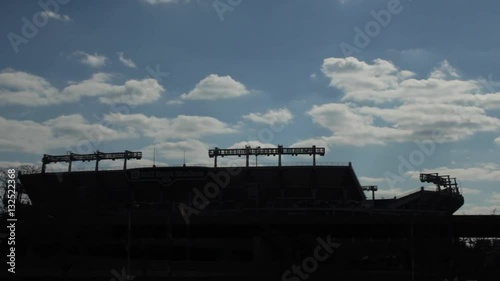 Time lapse of clouds moving over football stadium in silhouette