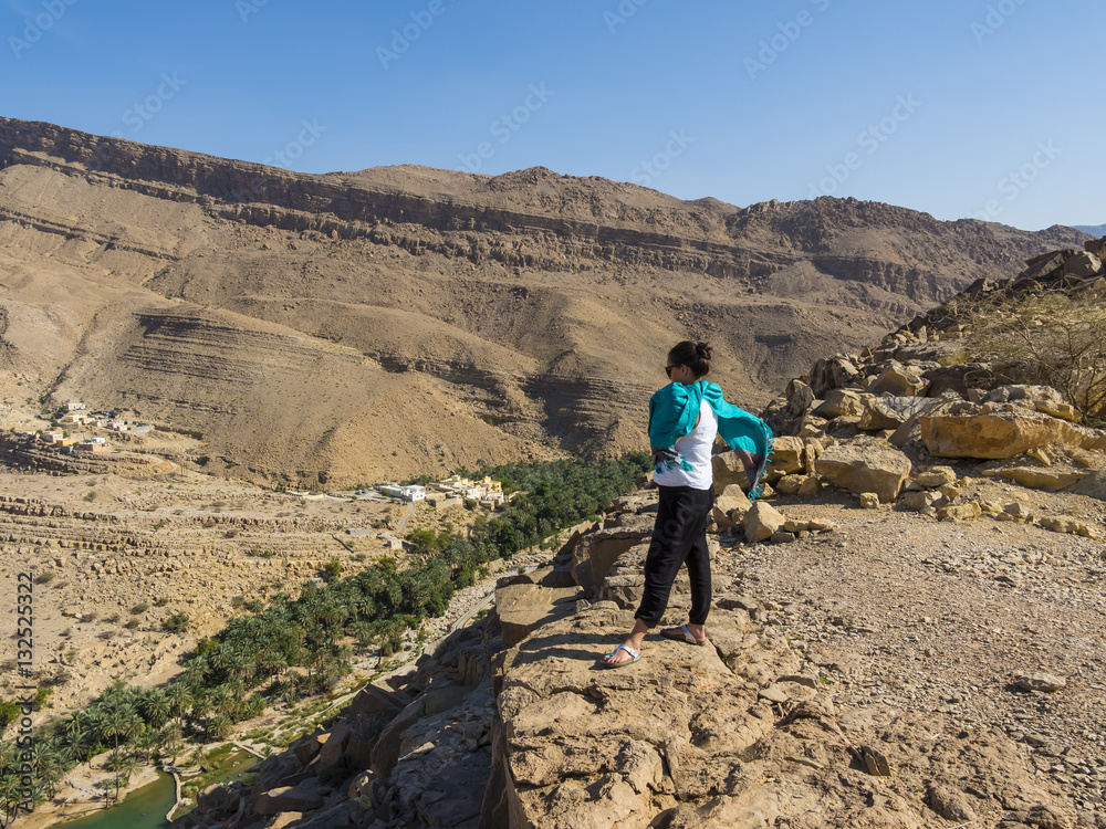 Sultanat Oman, Sharqiya Region, Muqal,  Wadi Bani Khalid, Junge Frau schaut auf den Süsswassersee von Wadi Bani, Khalid