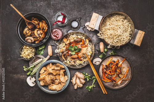 Asian  stir-fry wok with chicken, noodle and vegetables, top view composing on dark vintage background.