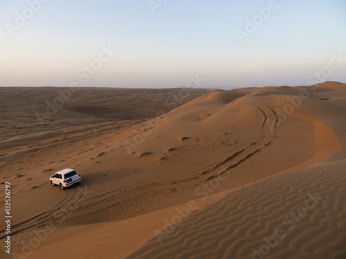 Mittlerer Osten , Arabien, Sultanat Oman,Al Raka, ein Geländefahrzeug steht in den Sanddünen der Wüste Rimal Al Wahiba oder Wahiba Sands, auch Ramlat al-Wahiba oder Scharqiyya Sands, im Abendlicht
