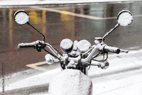 Motorbike parked on the street covered with snow