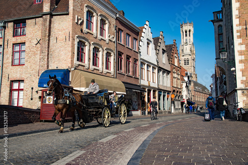 Historic brick house in Bruges with horse carriage