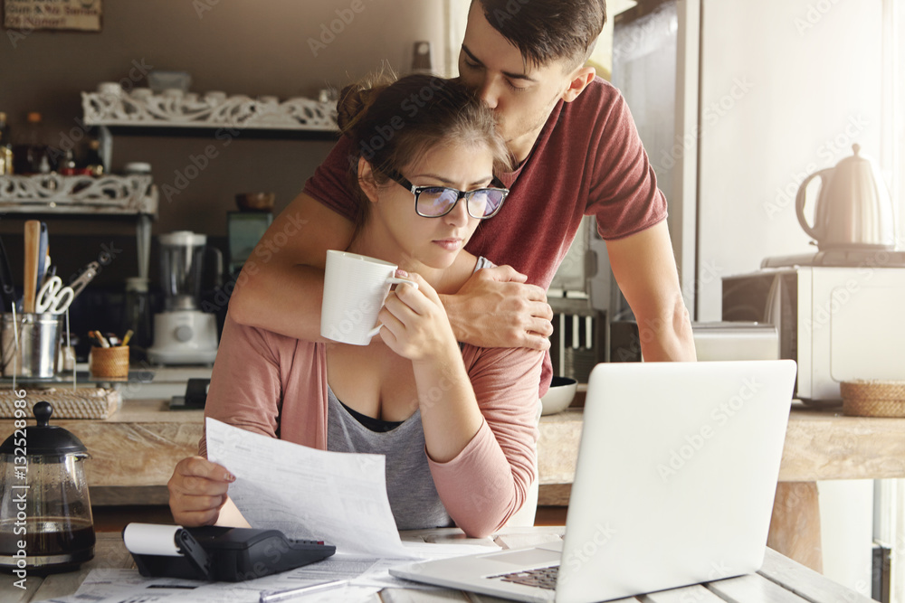 Unhappy Caucasian family having economic trouble, not able to pay out debts. Supportive young man trying to cheer up his worried wife in glasses who is feeling stressed, facing financial problem Unhappy Caucasian family having economic trouble, not able to pay out debts. Supportive young man trying to cheer up his worried wife in glasses who is feeling stressed, facing financial problem