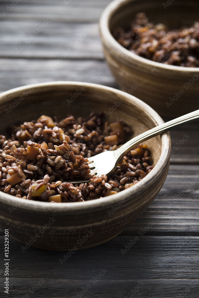 red rice in a clay plate. healthy diet. complex carbohydrates red rice in a clay plate. healthy diet. complex carbohydrates